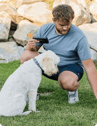 Owner kneeling on the lawn drawing a boundary in the app